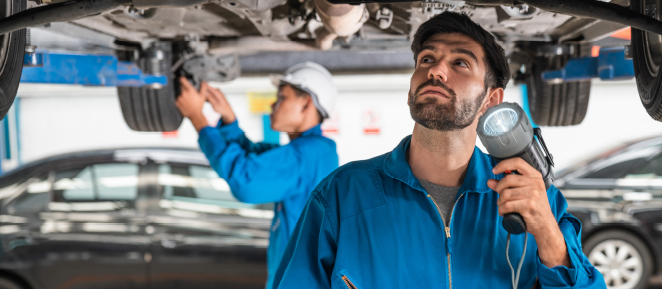 Técnico revisando vehículo elevado